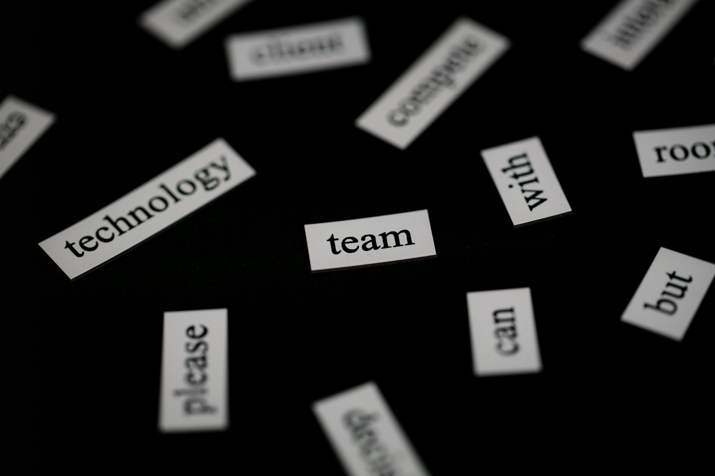 Litery Scrabble ze słowami biznesowymi ułożone na czarnej powierzchni.